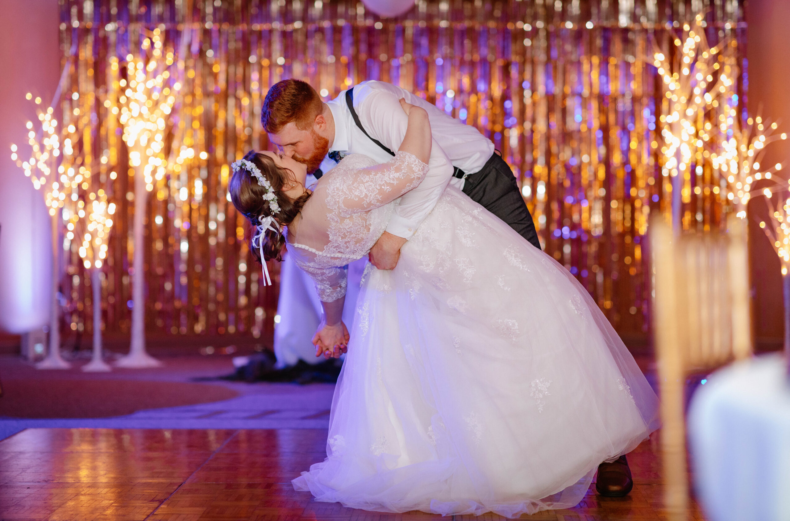 Groom dips bride on dance floor